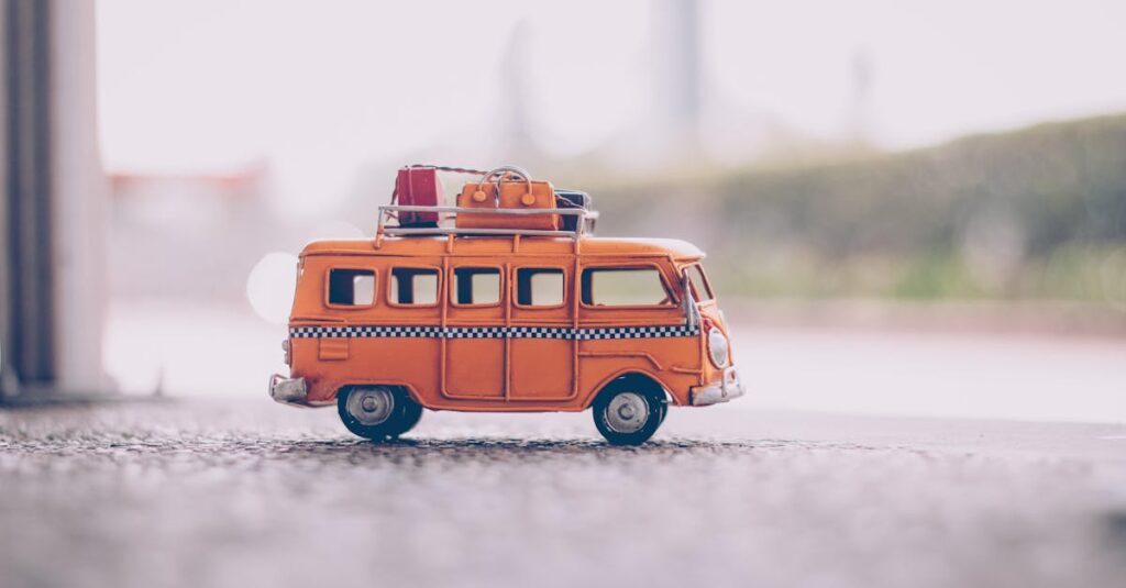 Close-up of a vintage orange toy van with luggage on a textured surface, capturing a nostalgic travel vibe.